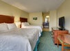 Guest room with two queen beds, flat -screen TV, and a desk and chair.
