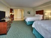 Guest room with two queen beds, coffee maker, mini fridge, and a flat screen TV.
