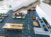 Aerial view of a modern lobby with patterned blue carpet, sofas, armchairs, a long wooden table with chairs, and a staircase.