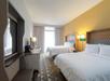 Two queen beds, flat-screen TV, a coffee maker, and a work desk