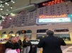 A group of people stands on a city sidewalk at night near the Roosevelt Hotel and Cinegrill neon signs.