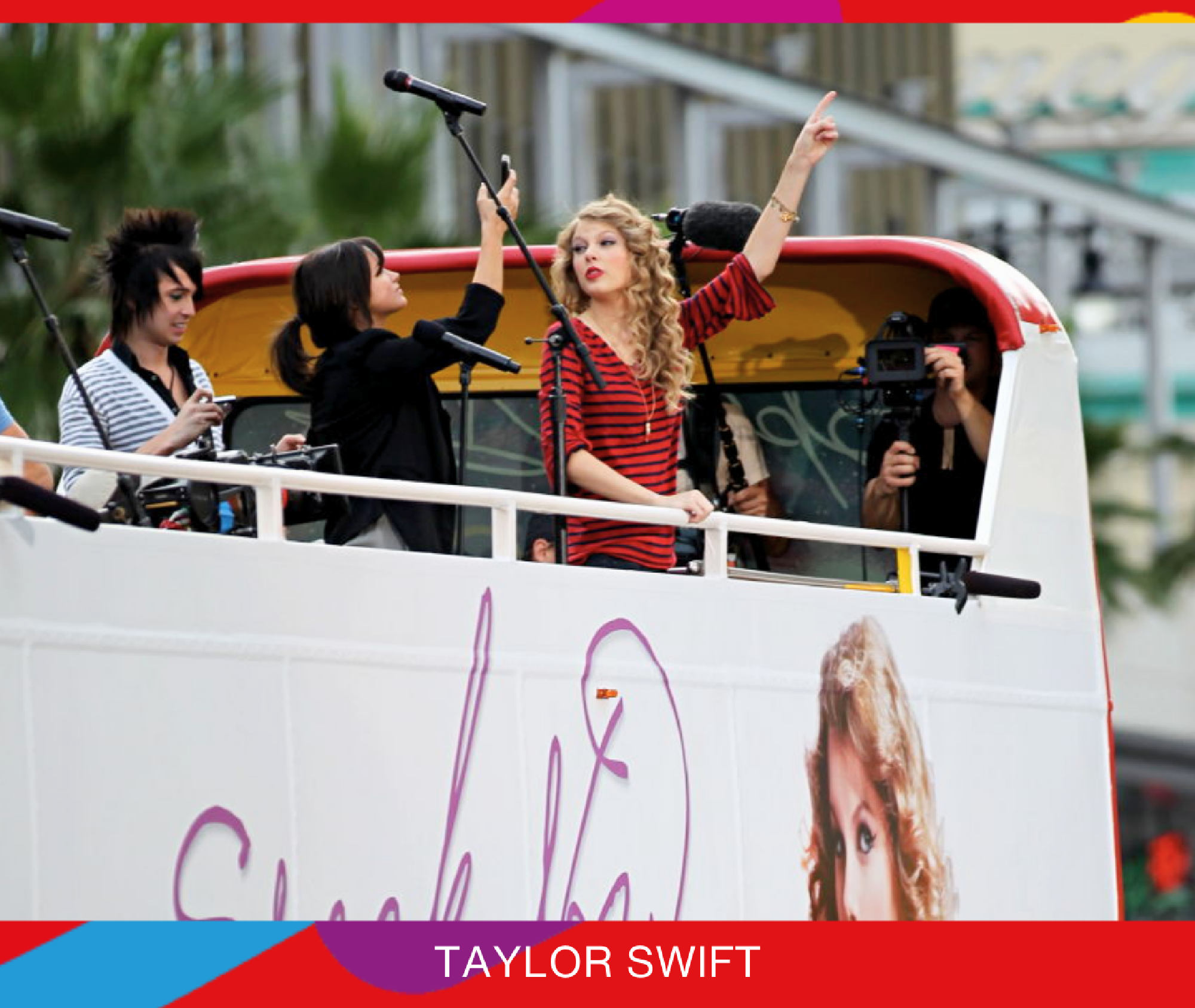 A woman in a red striped shirt stands on an open-top bus holding a microphone, surrounded by crew and filming equipment. The bus features her image.