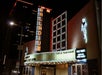The Palladium theater at night with marquee displaying event details for February 22, 2025, and neon lights illuminating the entrance.