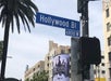 Street sign for Hollywood Blvd at 6800W, with palm tree and buildings in background. A billboard for "The Nevers" is visible.