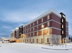 Beautiful landscaped hotel exterior with street lights.