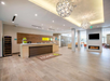 Hotel lobby with a modern design, featuring a front desk, seating area, decorative lights, and an electric fireplace.