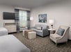 Two double beds, a work desk and chair, seating area/sofa and a flat screen TV.