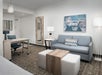 A living area with sofa, desk and chair.