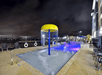 An outdoor pool with a kids play ear at night with blue lights illuminating the water at the Homewood Suites by Hilton New Braunfels.