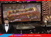A large screen at the Oscars displays an image of a red sightseeing bus; Jimmy Kimmel stands on stage with the audience seated below.
