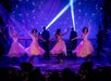 Women in pink sparkly tule dresses dancing on stage at Hot Rods & High Heels in Branson, Missouri.