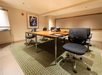 Meeting facility with a large table, executive chairs and a white board.