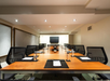 Meeting facility with a large table, executive chairs, and a flat-screen TV.