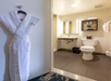 Back-lighted mirror, fresh towels, complimentary toiletries and a bathrobe inside a private bathroom.