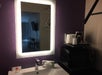 Back-lighted vanity mirror in a guest room.