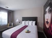 One king bed and soft seating inside a guest room.