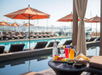 Outdoor poolside relaxation with cozy sun loungers.