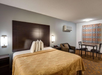 One king bed, an armchair, and a dining table for two.