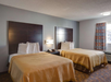 Two queen beds, a nightstand and a telephone inside a guest room.