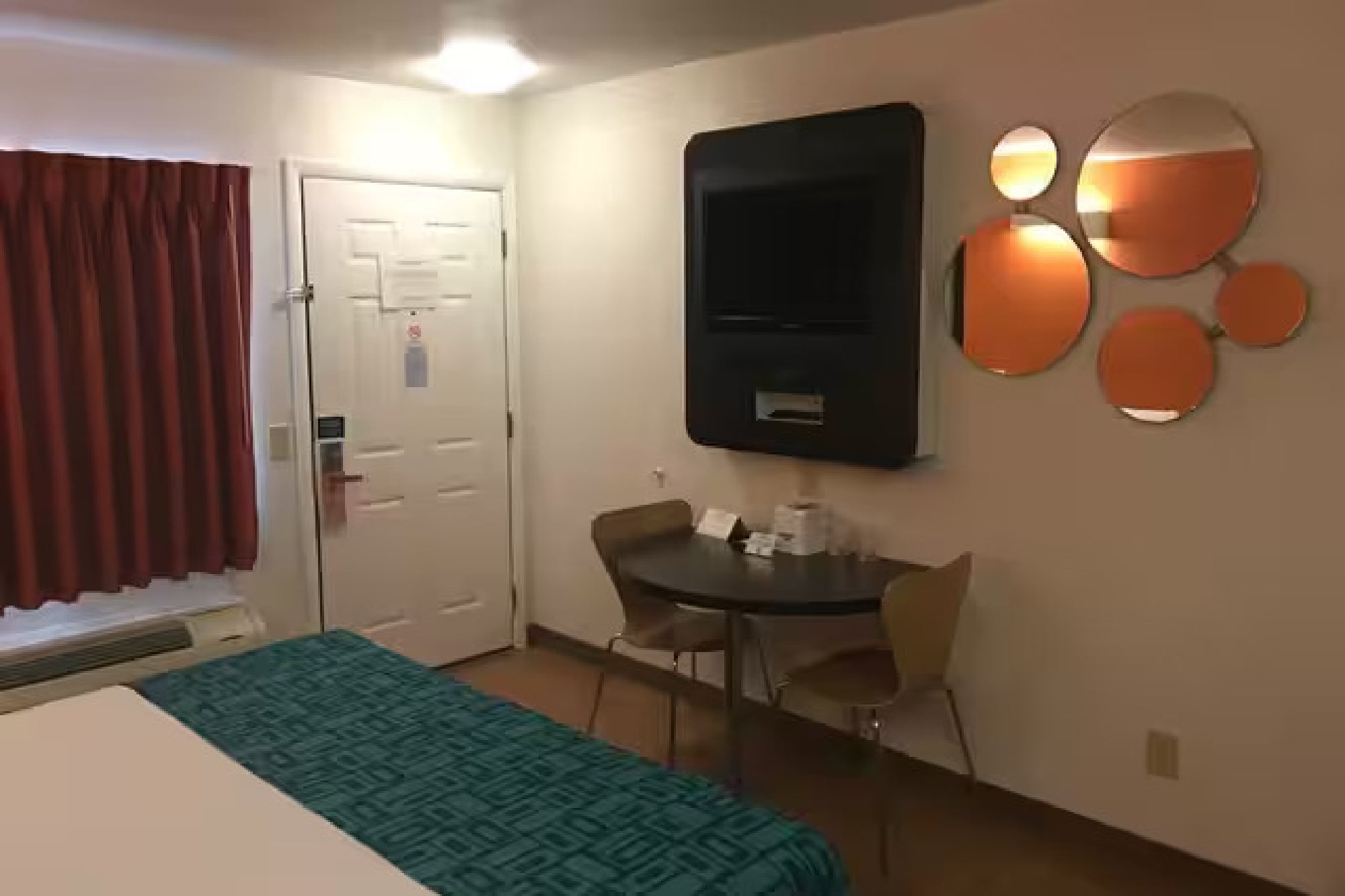 Room layout showing a small dining table and a wall-mounted television