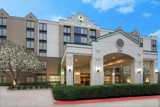 Beautifully landscaped entrance to the hotel with the hotel sign.
