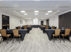 Meeting facility with white projector screen and a classroom type chair setup.