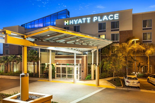 Entrance of a Hyatt Place hotel at dusk, with a covered driveway and well-lit exterior.