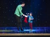 Illusionist Jason Hudy holding a Christmas stocking with an audience at the stage.