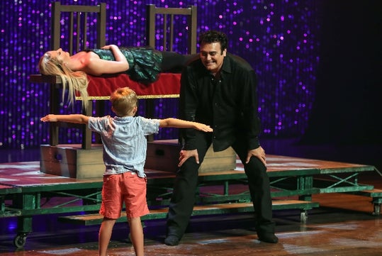 Rick Thomas demonstrating a trick with a child.