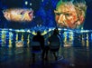 Two people seated, viewing a digital art display featuring Van Gogh's face and vibrant night scenes with reflections on water.