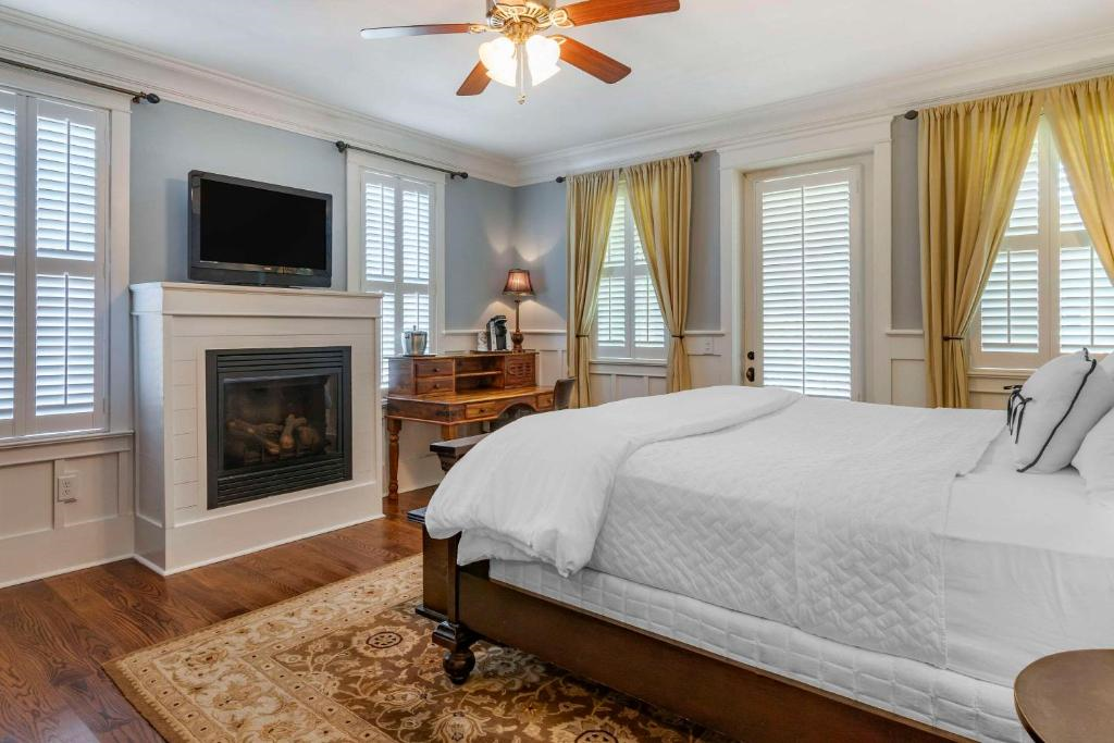 A king bed, work area, fireplace, and a flat-screen TV