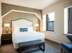 One king bed, bed side lamps and two large windows with a view.