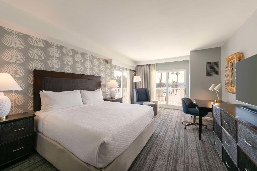 Guest room with one king bed, seating area, work desk, and flat-screen TV.
