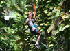 A kid is riding the zipline at the Jungle Zipline Maui Eco Tour.