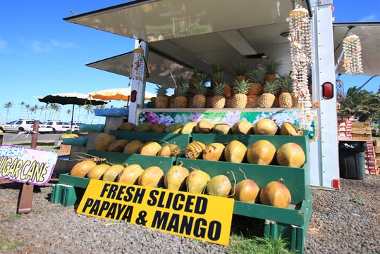 Fresh sliced papaya, mango and pineapple quaint store in Kapaa Town.
