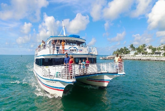 Tour guests on the glass bottom boat with the shoreline in the background on the Key West Glass Bottom Boat Tour, Key West Florida.