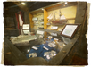 A museum display case with ship models, coins, artifacts, informational placards, and a framed label reading "CISTER El Cazador.