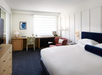 One king bed, work desk, and flat-screen TV inside a guest room.