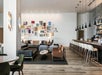 Spacious modern lounge with couches, framed artworks on the wall, and a bar area with high stools and hanging lights.