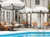 Outdoor pool with sun loungers and umbrellas at  Lighthouse Hotel, Key West FL.