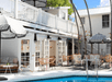 Outdoor pool with sun loungers and umbrellas at Lighthouse Hotel, Key West FL.