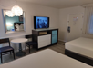 Relax in a guest room with two beds, dining table for two, mini fridge and a flat-screen TV.