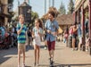 Three guests enjoy a snack as they stroll through Knott's Berry Farm near Los Angeles, California.