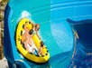 A family in a large yellow tube riding The Wedge water slide at Knott's Soak City Water Park in Los Angeles, California.