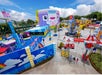 A vibrant and colorful LEGO-themed amusement park area, featuring various attractions, buildings, and playful designs under a bright blue sky.