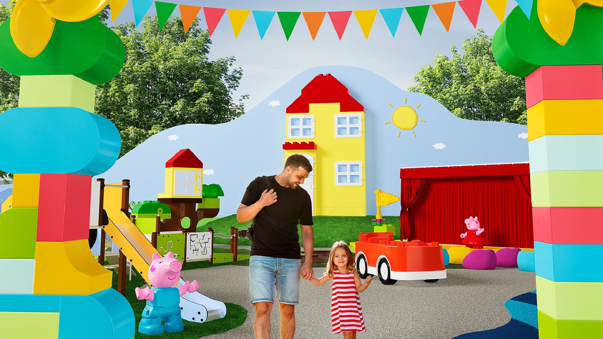 A man and a child walk hand in hand in a colorful outdoor theme park with large play structures and cartoon character illustrations.