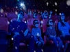 A theatre full of parents and children wearing 3D glasses and laughing at LEGO Discovery Center Boston.