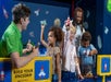 Several children and parents building rockets at the Build Your Spaceship exhibit at LEGO Discovery Center Boston.