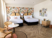 2 Double beds and a living/sitting area inside a guest room.