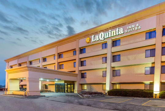 A La Quinta Inn & Suites hotel building at dusk, with lit windows and a visible entrance.